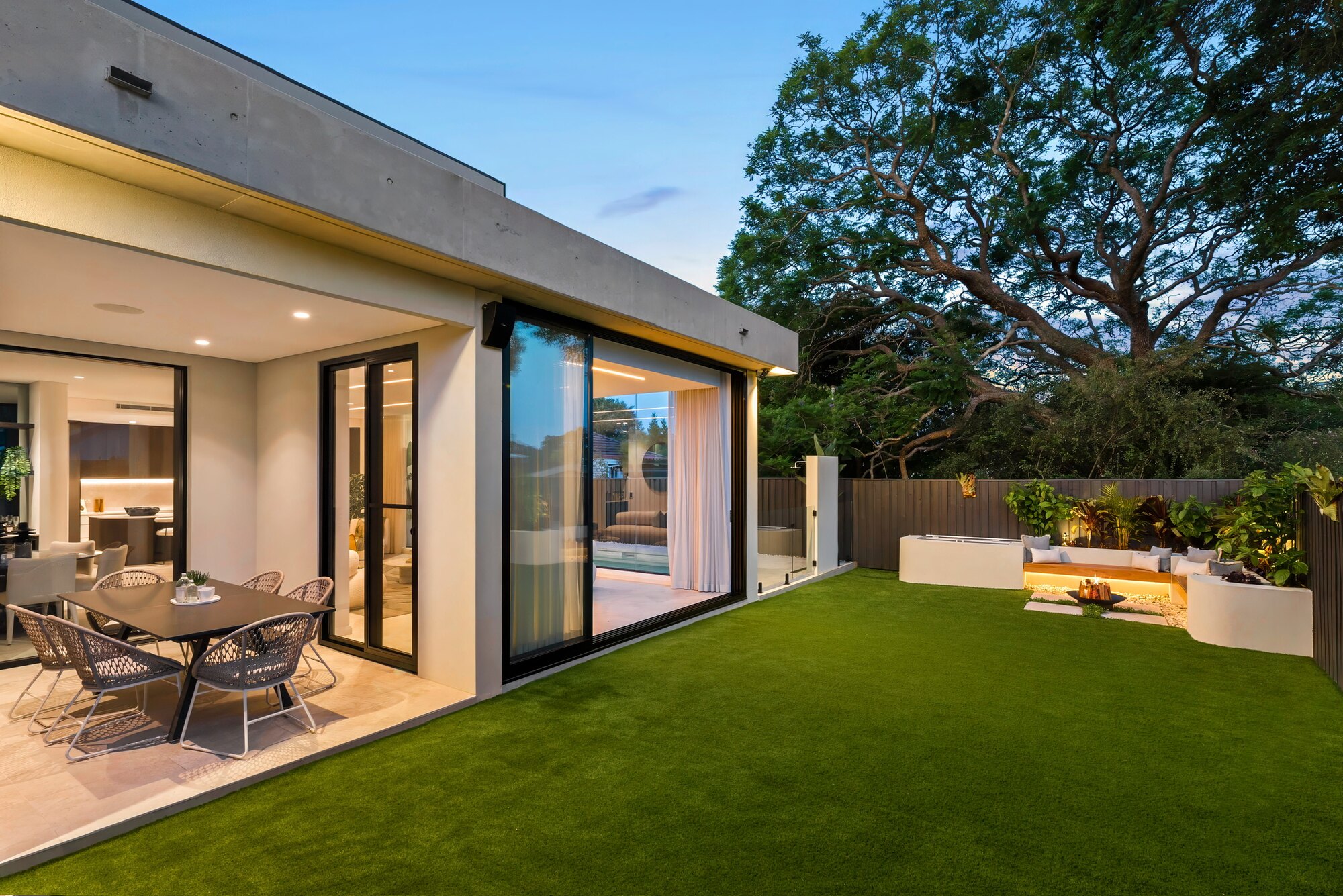 Landscaped backyard with lawn, garden beds and outdoor dining area