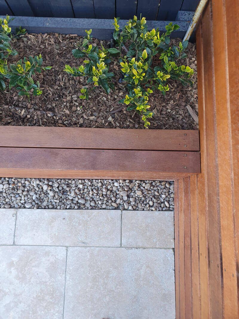 Raised timber garden bed beside a paved area